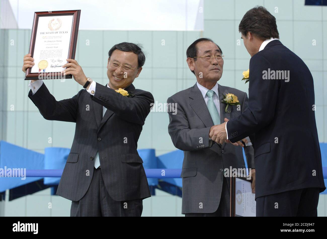 FILE Austin,TX June 14, 2007: Dr. Chang-Gyu Huang (l) and CEO Jong-Yong Yun (c) receive an 'honorary Texan' award from Texas Governor Rick Perry (r) at grand opening ceremonies at Samsung Austin Semiconductor (SAS) for 'Fab 2' manufacturing facility showcasing the Korean chip manufacturer's multi-billion-dollar U.S. investment.  ©Bob Daemmrich Stock Photo