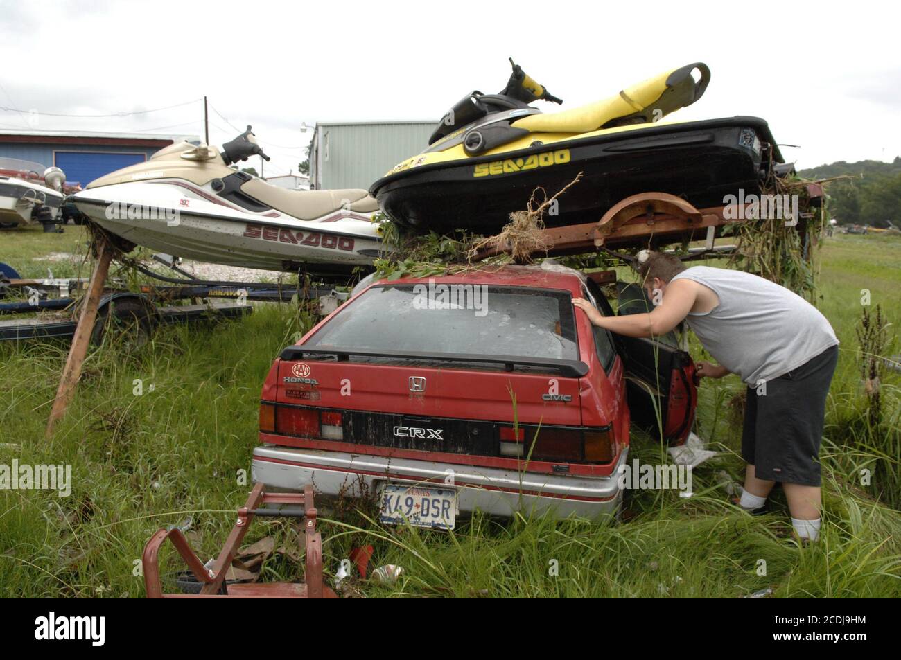 Marble Falls, TX  June 27, 2007: Owner Andrew Bruseau inspects his flooded car after up to 19 inches of rain in a few hours fell on the Marble Falls area, resulting in property damage in the millions as creeks overflowed an industrial area. No deaths were reported.        ©Bob Daemmrich Stock Photo