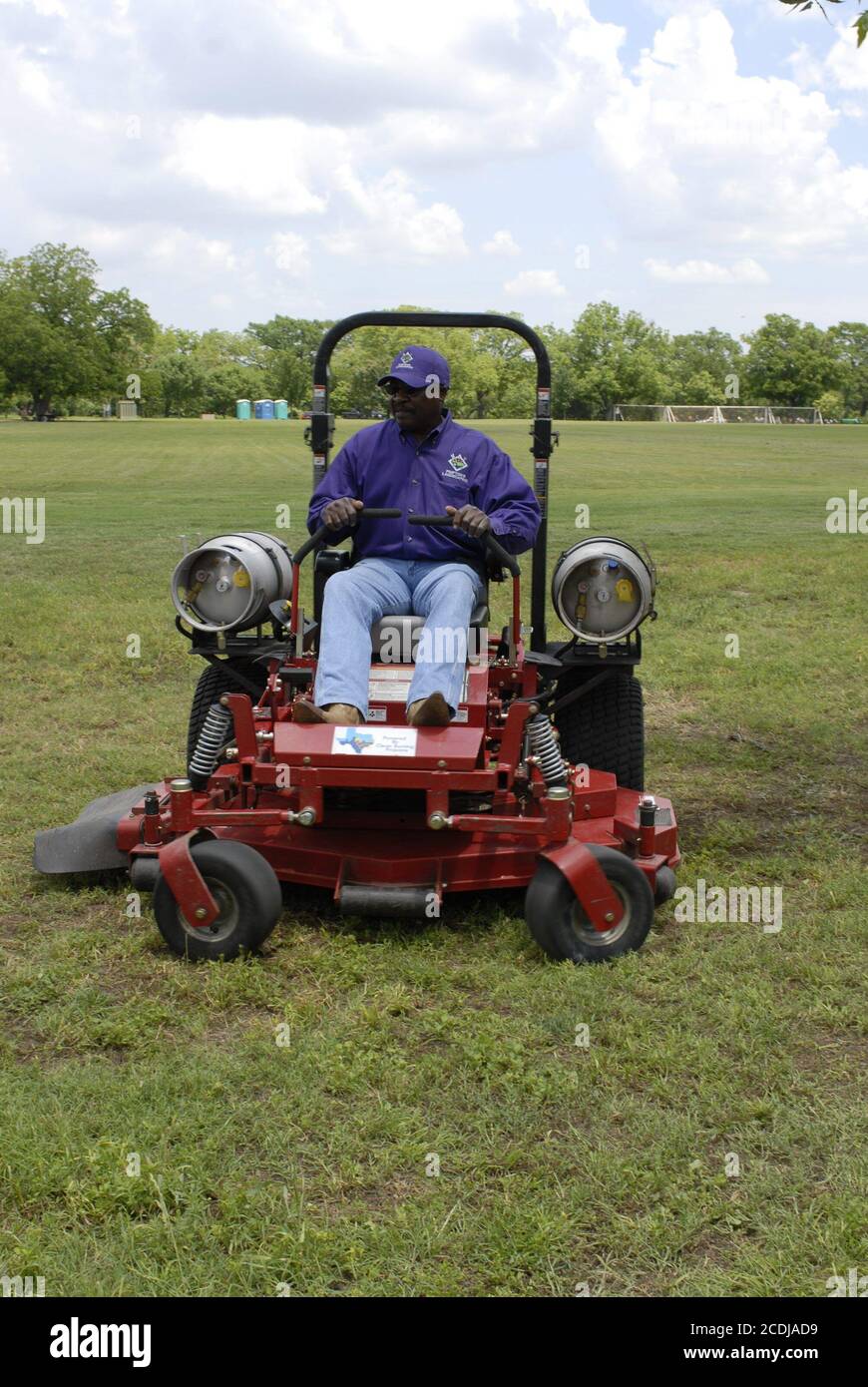 Austin, Texas USA, May 11 2007: Propane-powered commercial lawn mower cuts grass at city park.  ©Bob Daemmrich Stock Photo