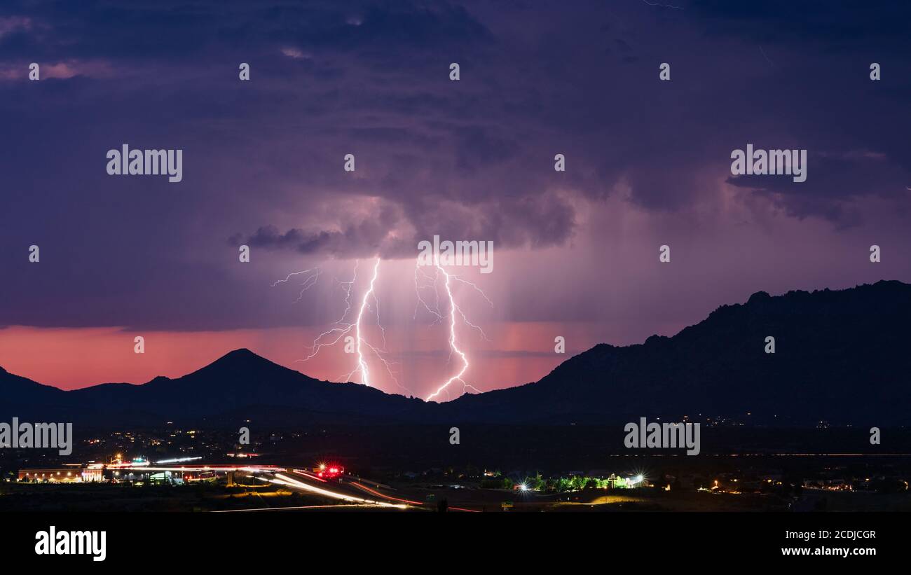 Lightning bolts from a monsoon storm illuminates the evening sky over Prescott, Arizona Stock Photo