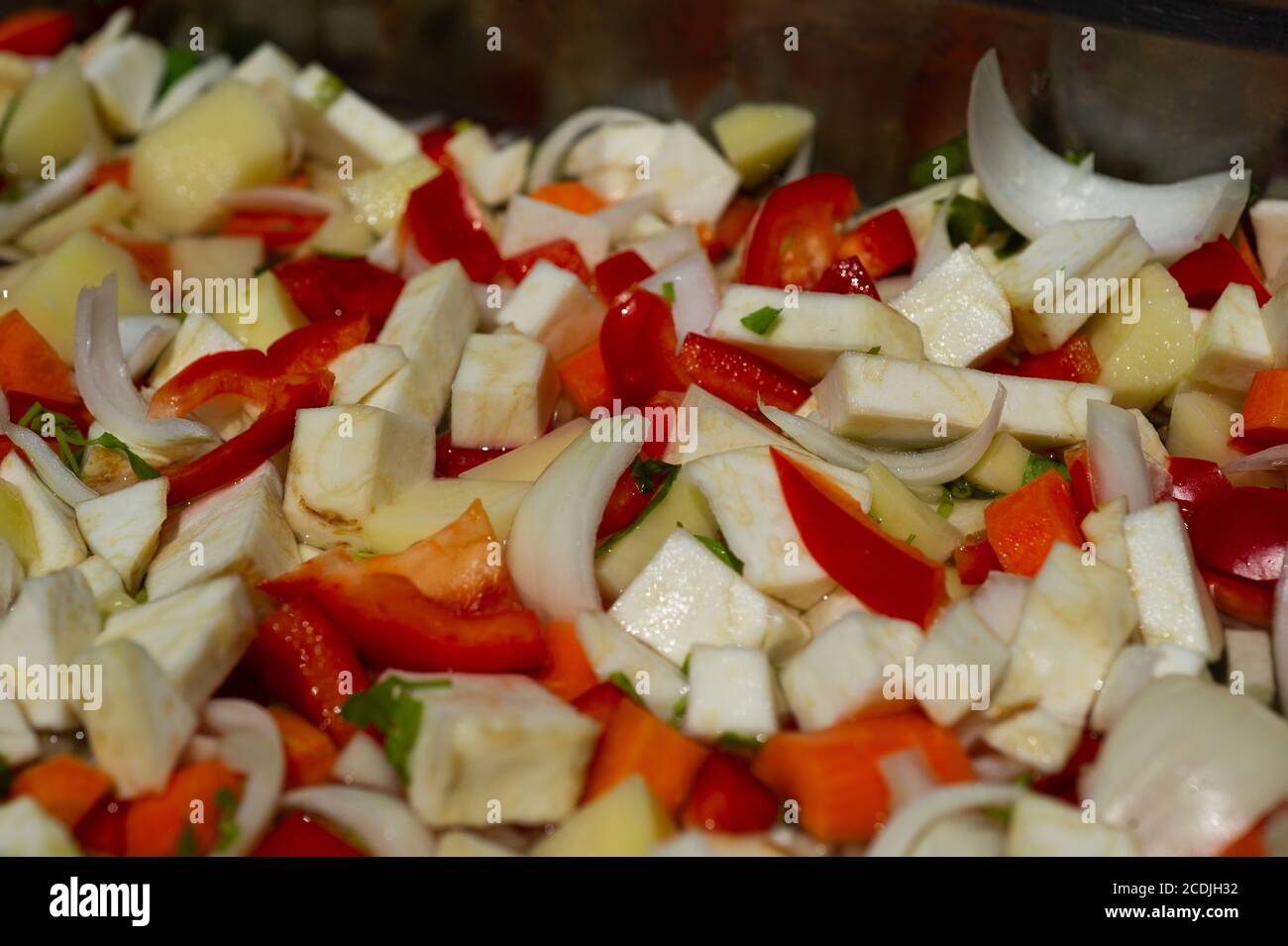 Fresh vegetables are chopped, flame grilled and boiled on an outdoor fire to prepare soup stock. Stock Photo