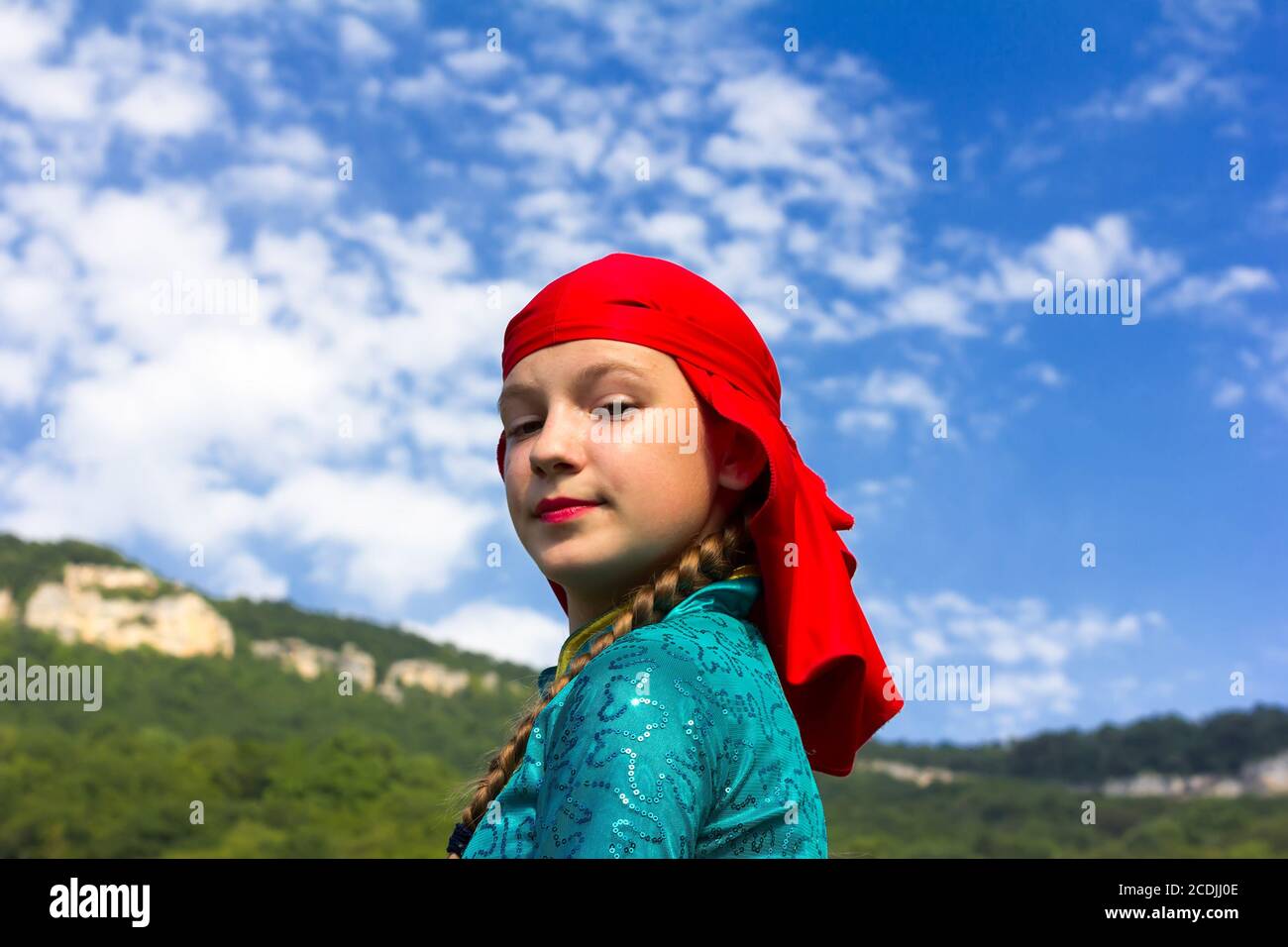 Adygea, RUSSIA - JULY 25 2015: Portrait of a young dancer in traditional Circassian dress on a background of sky and mountains. Ethnic festival in the Stock Photo