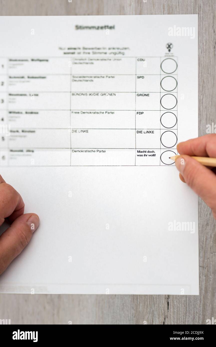 Brilon, North Rhine Westphalia/ Germany: August 27th 2020: A man sits in front of a ballot for the election. German party name and a fictitious German Stock Photo