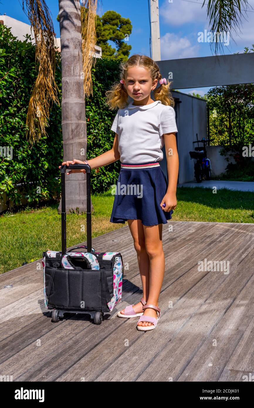 Girl is sad and angry because she has to go back to school. I don't want to go to school. Warm background Stock Photo