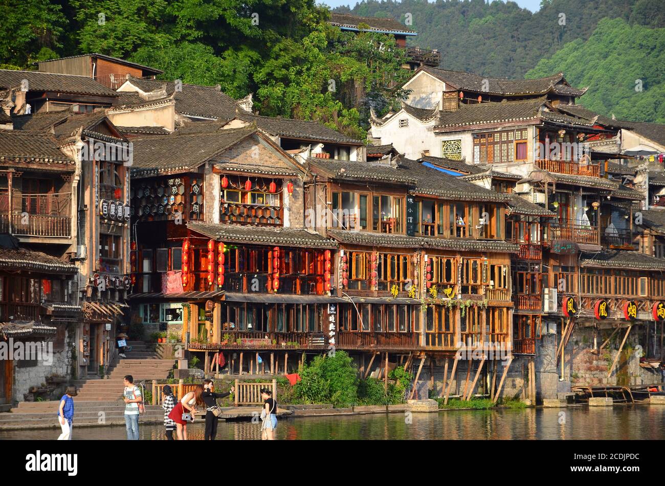 Fenghuang, China - May 15, 2017: Old building with people in food court on riverside near Phoenix Hong Bridge in Fenghuang Stock Photo