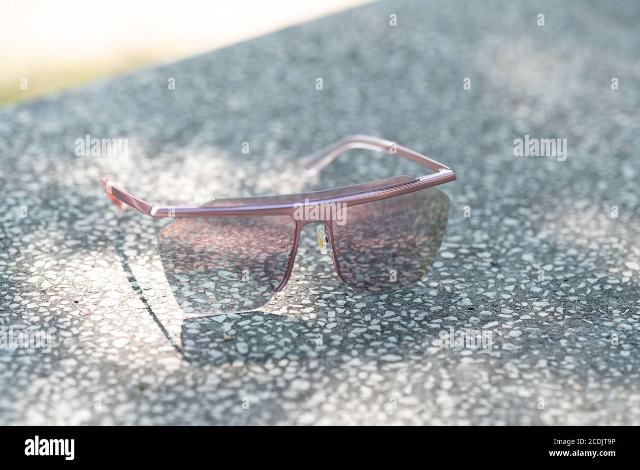 Oversized sunglasses model with big pink lenses shoot in a summer day close up. Selective focus  Stock Photo