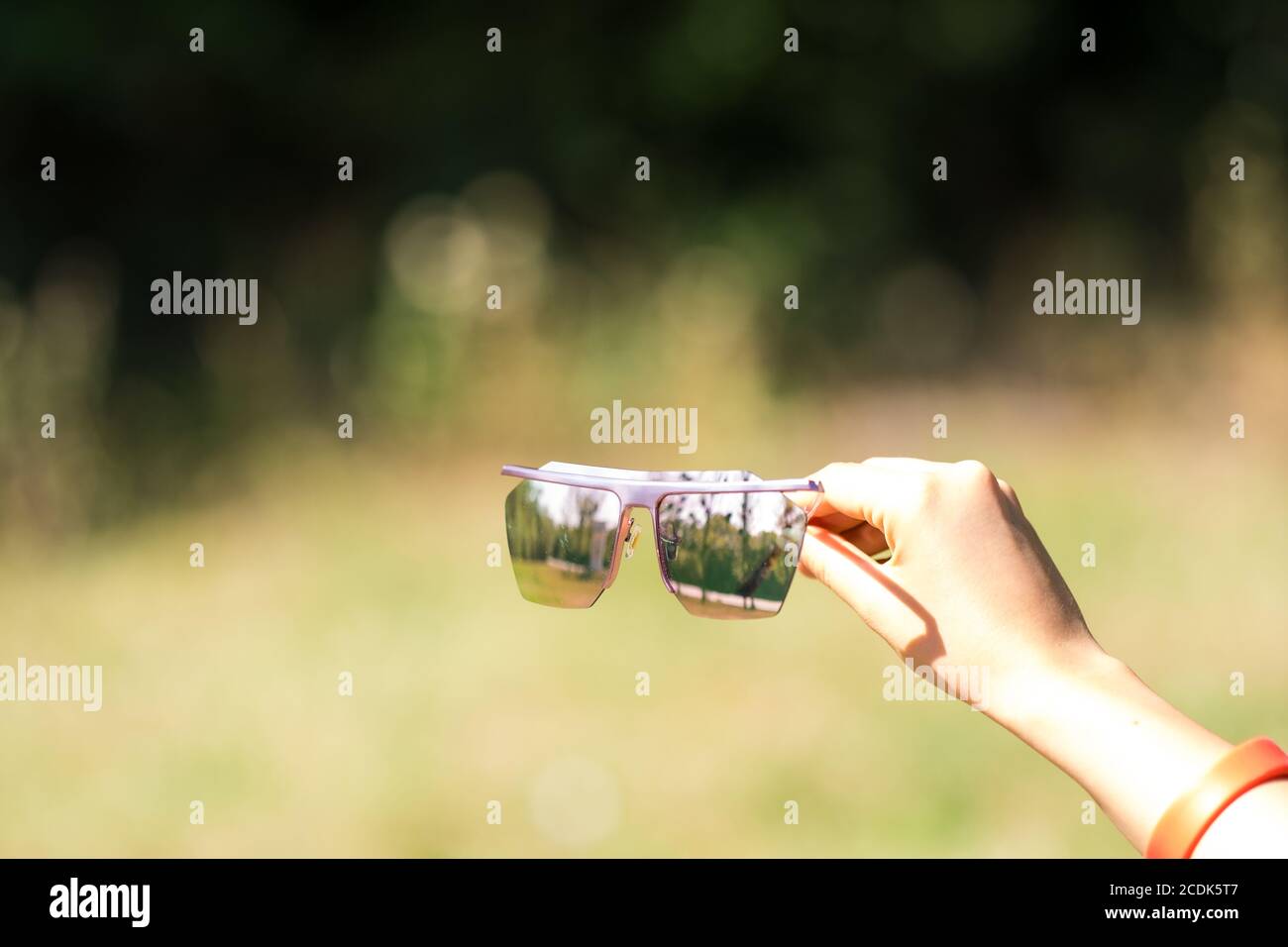 Oversized sunglasses model with big pink lenses shoot in a summer day close up. Selective focus  Stock Photo