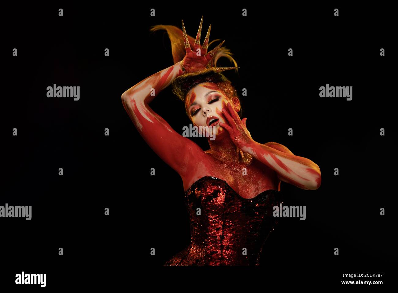 Young woman dancing in the image of Flames and Fire in a red body art ...