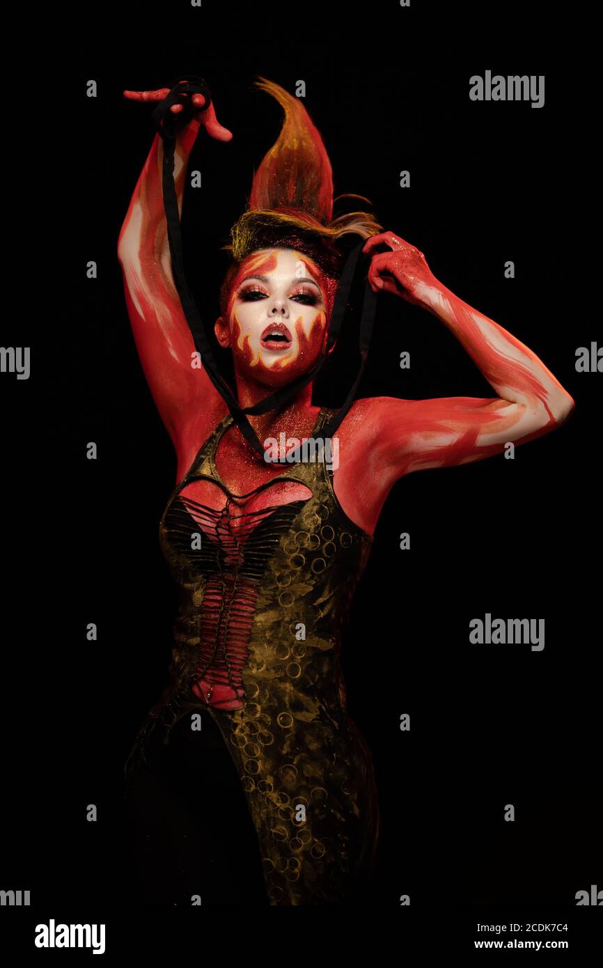 Young woman dancing in the image of Flames and Fire in a red body art ...