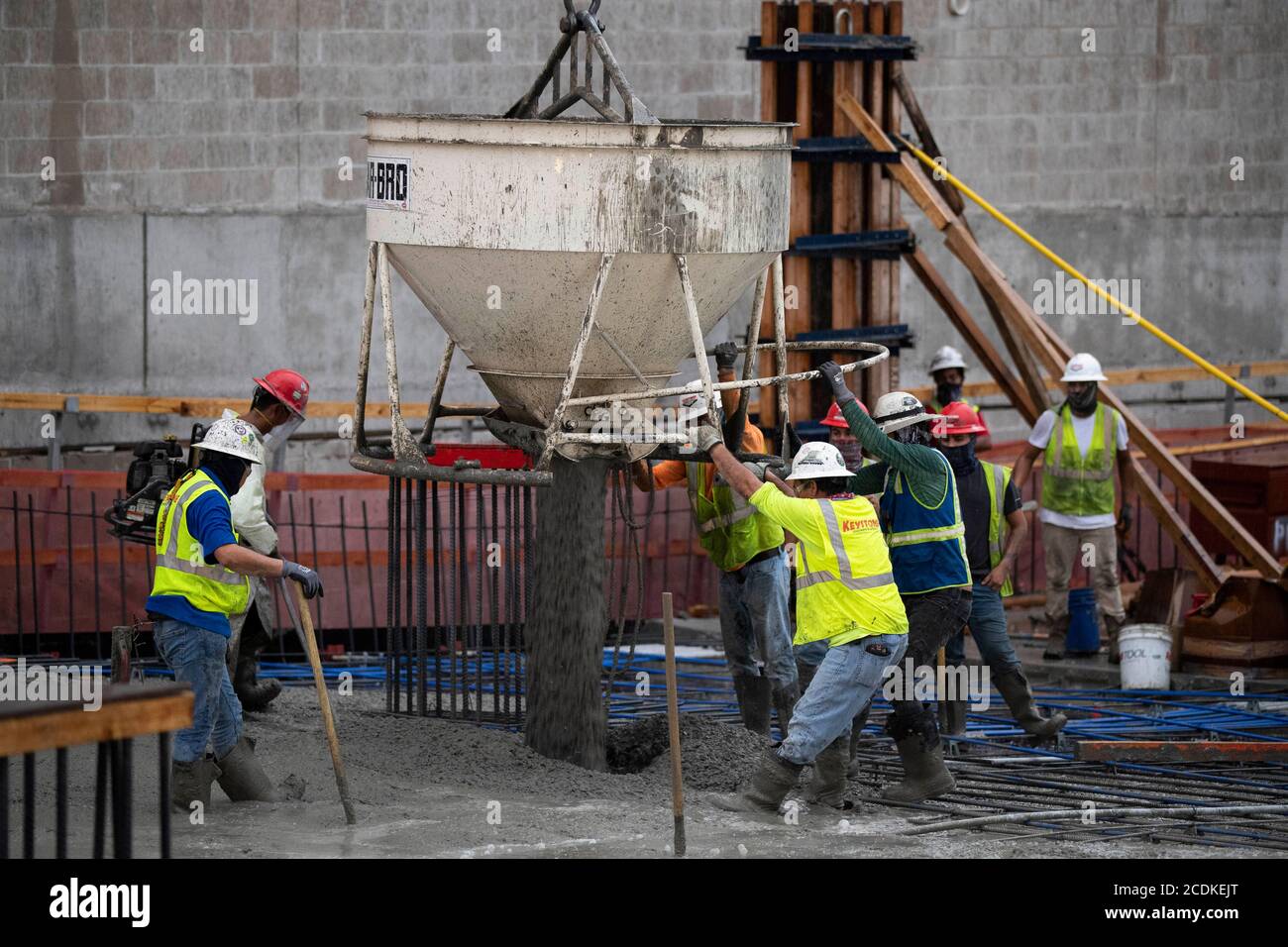 Austin, TX USA August 22, 2020: Experienced concrete crew conducts a night pour on the top floor of a high-rise parking garage in downtown Austin. Major construction projects continue unabated during the coronavirus shutdowns in Texas. Stock Photo