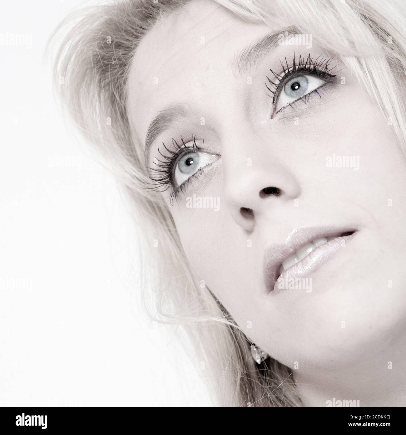 Studio portrait of a long blond girl looking up Stock Photo