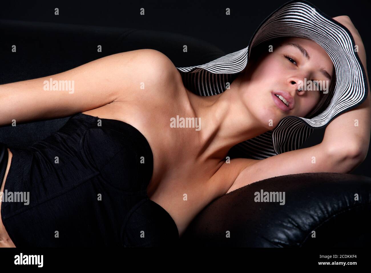 Young mult etnic woman in 50's lingery on couch Stock Photo