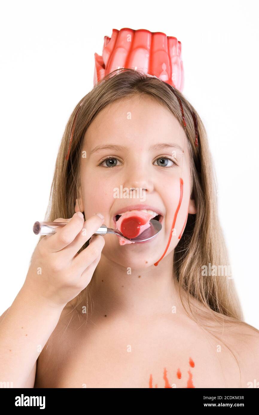 Blond child with desert on her head eating Stock Photo
