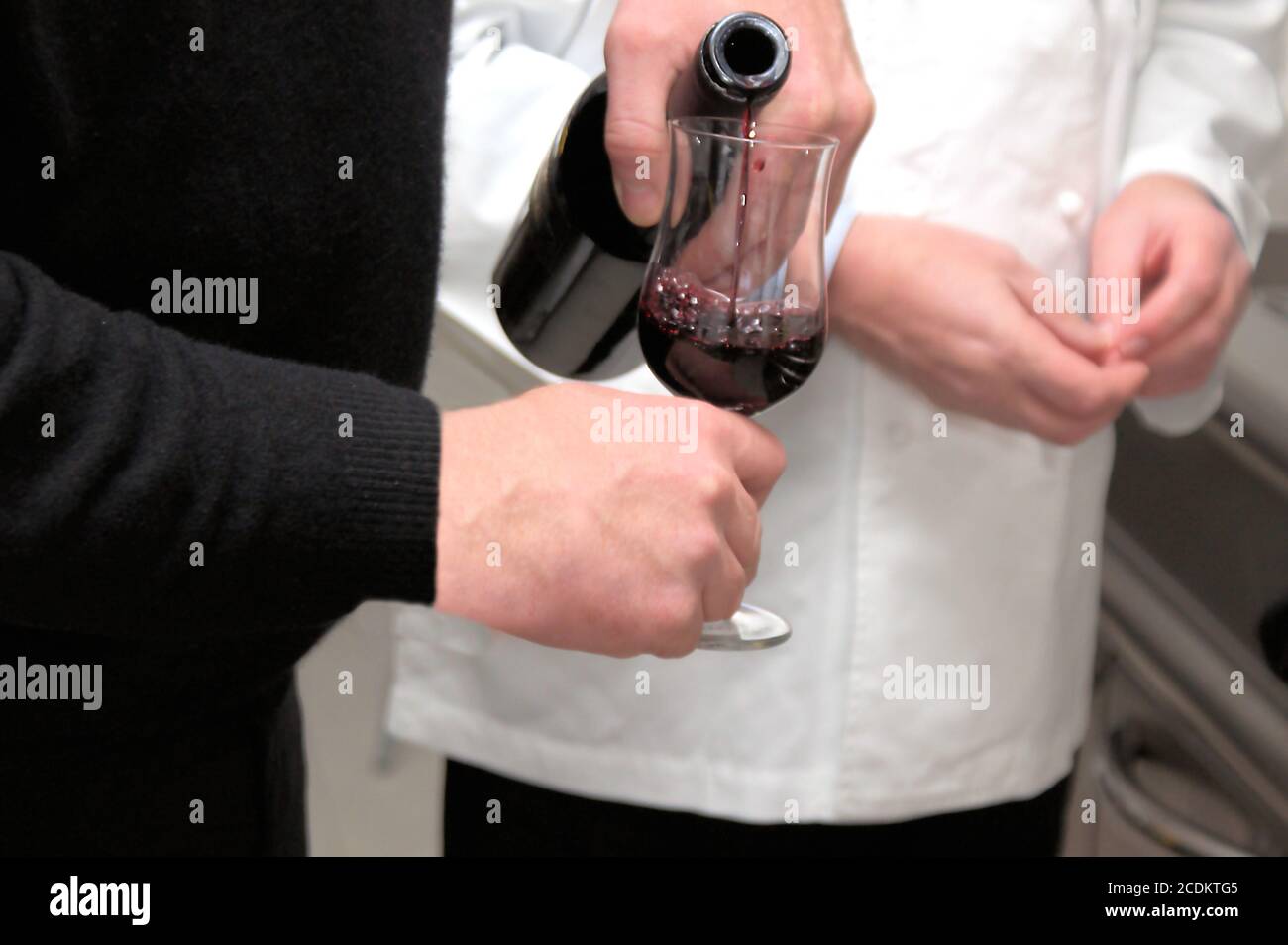 sommelier pouring redwine in a glass, bodyparts Stock Photo