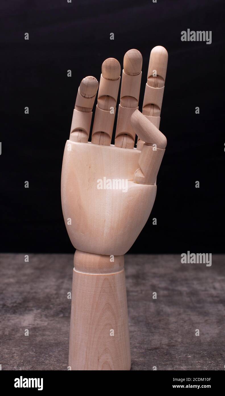 Wooden mannequin hand on dark background Stock Photo