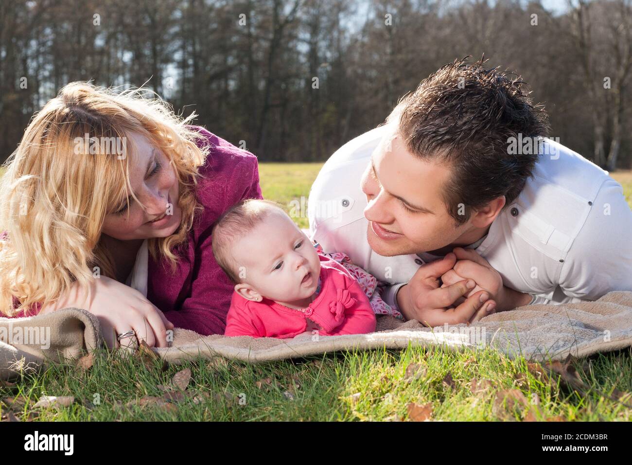 Young family on a blanket in the grass Stock Photo