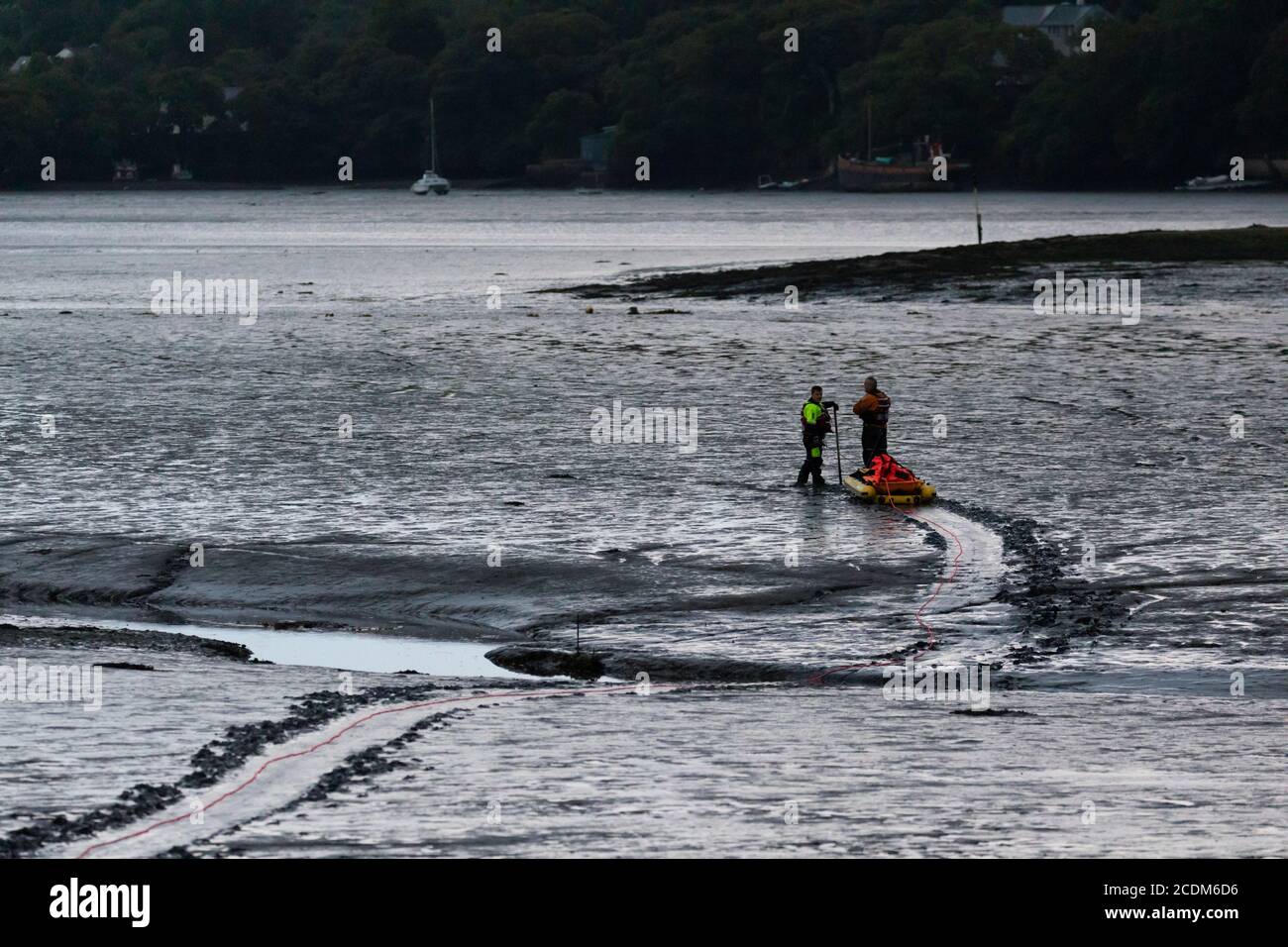 Rescue of Hire Boat boat aground in Restonguet Creek, Cornwall.  High tide is not due to float them off until 03AM and bad weather is expected. Stock Photo