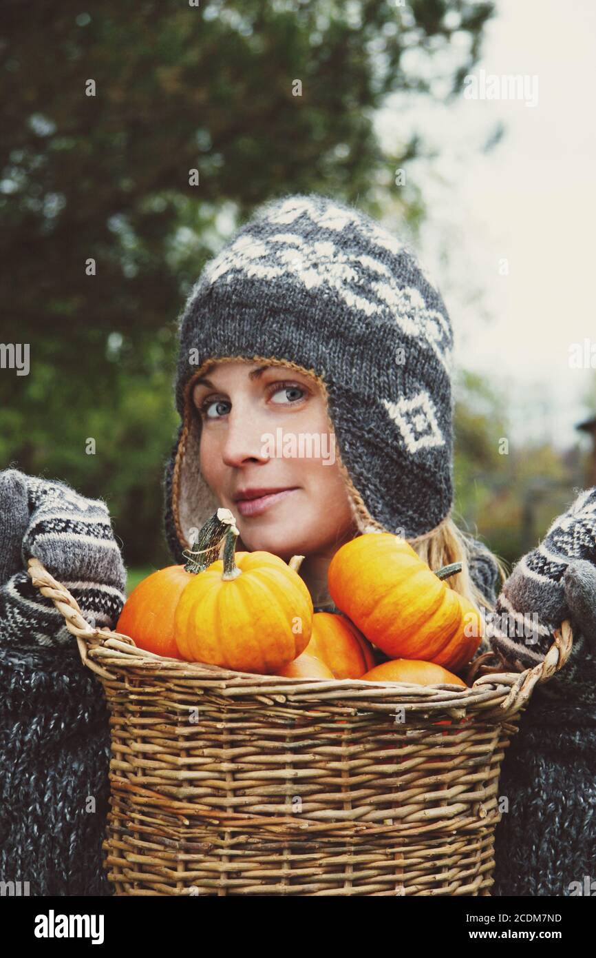 Girl holding basket of pumpkins Stock Photo