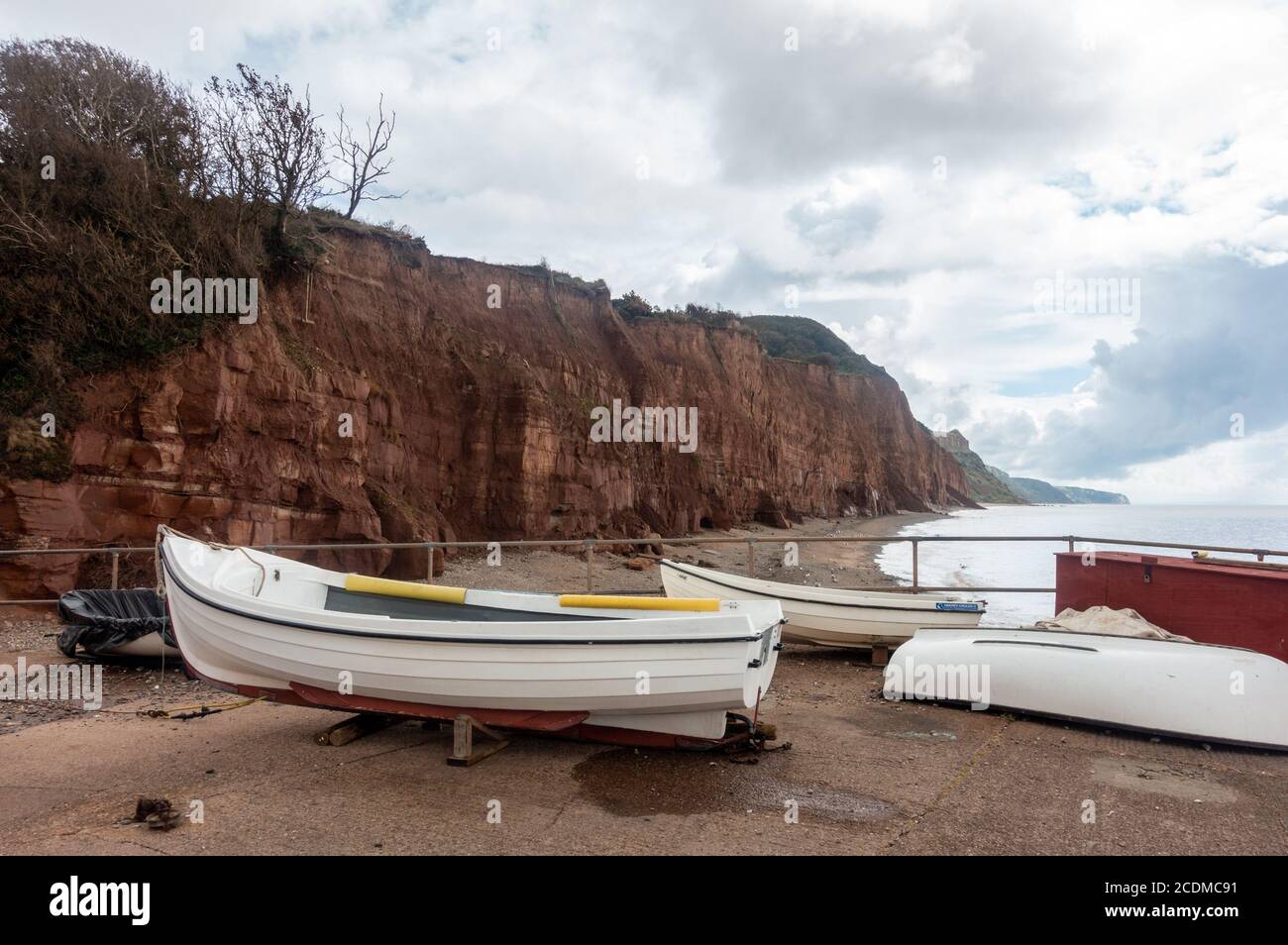 Boats on the quayside in front of red sandstone cliffs at Sidmouth in South Devon, UK Stock Photo