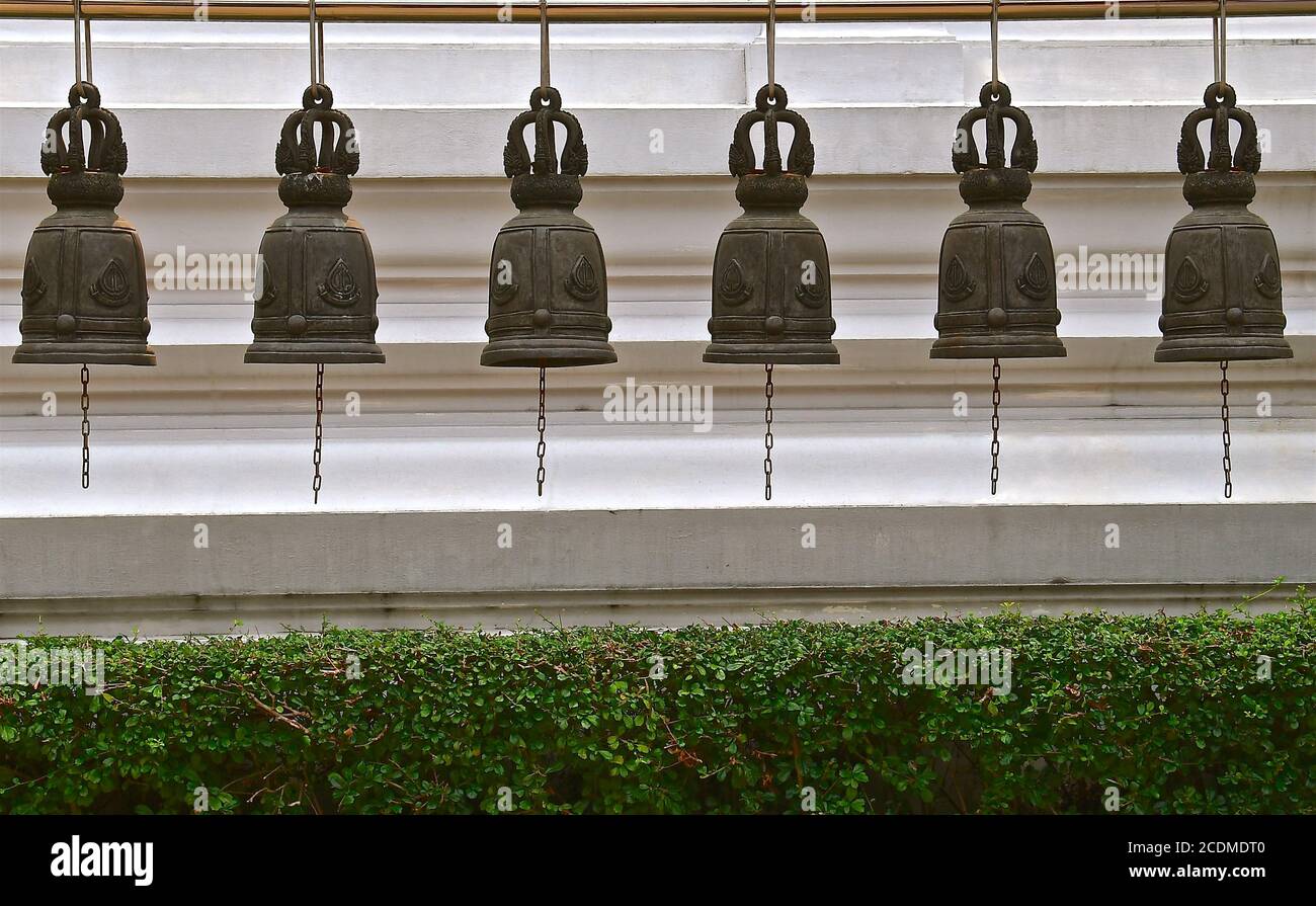 A row of six cast iron decorative temple bells in a buddhist temple in