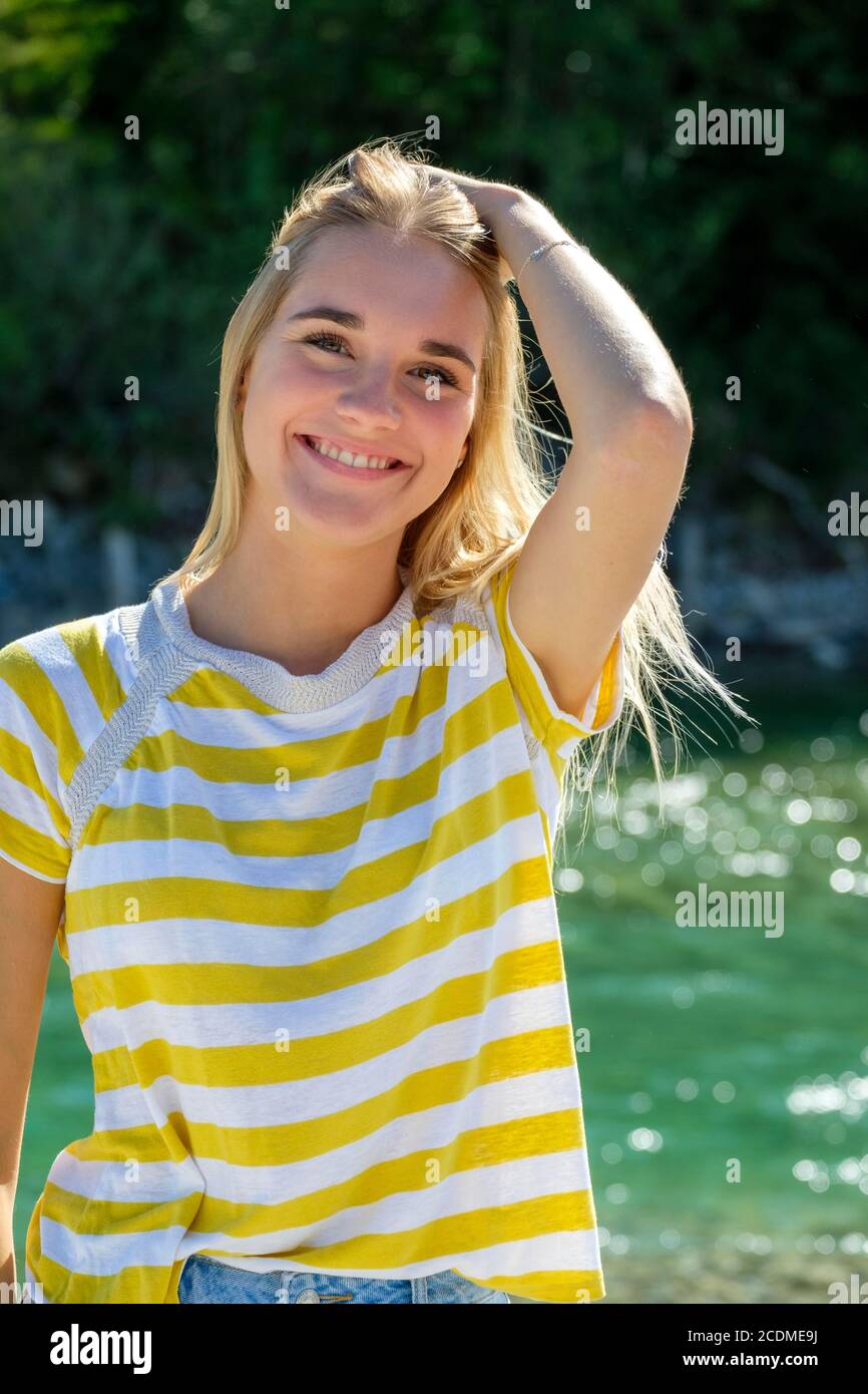 Portrait blonde young woman by the water, summer, Bavaria, Germany Stock Photo