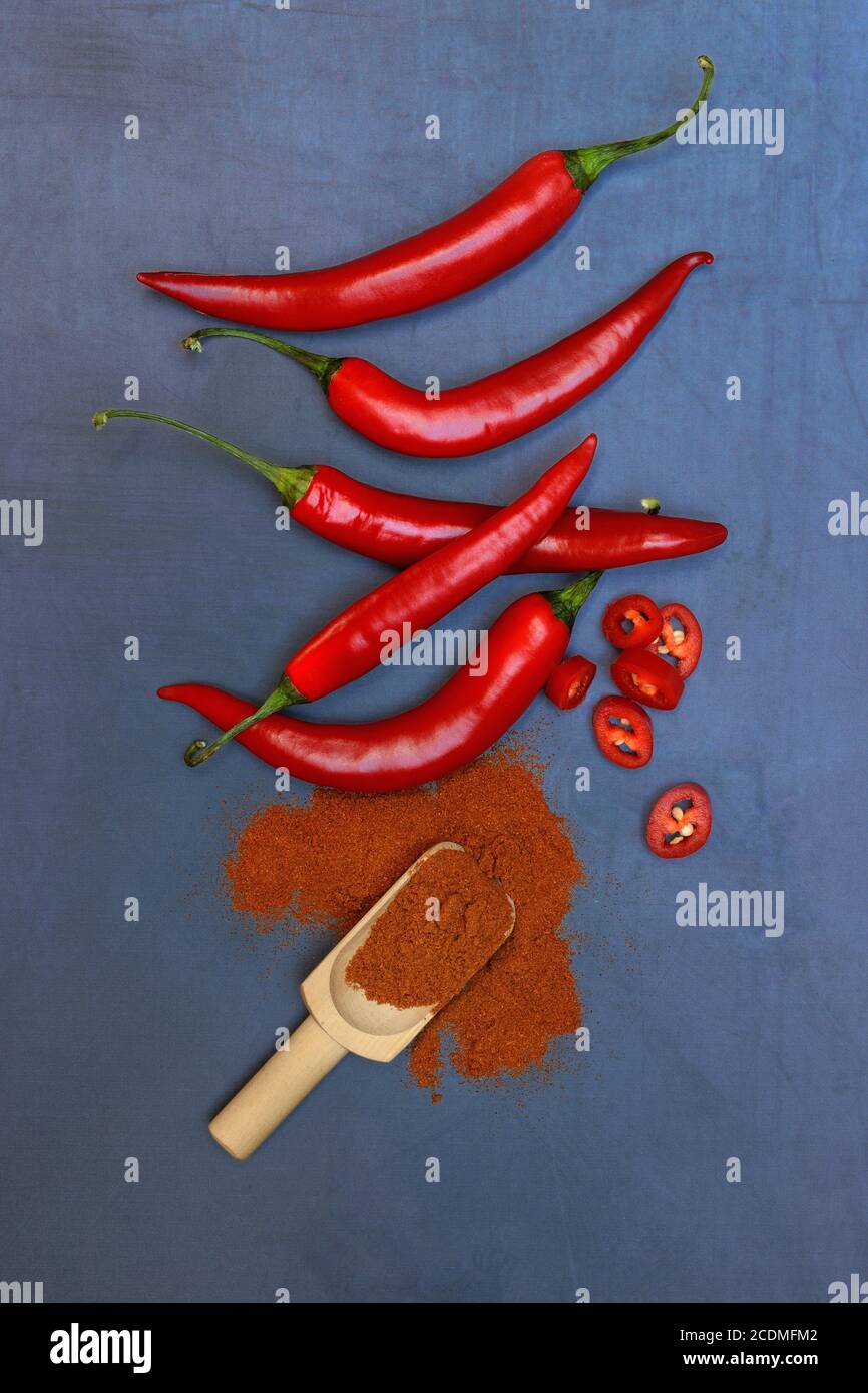 Chili powder in wooden shovel and chilli peppers, Germany Stock Photo