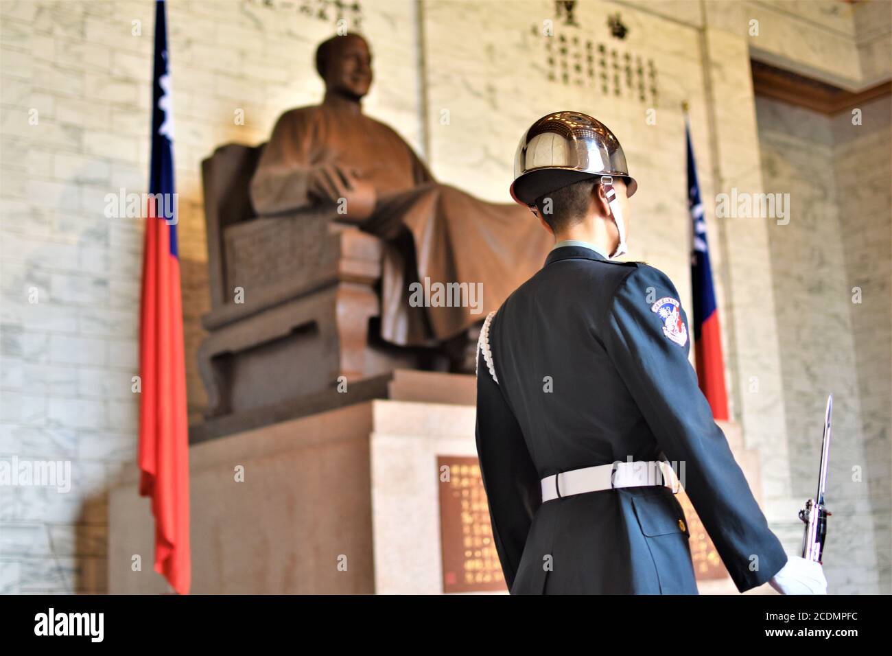 An honor guard in full ceremonial uniform stands beside the bronze statue of Chiang Kai-shek in Taipei Stock Photo