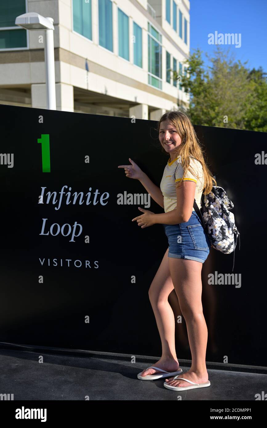 A teenage girl proudly posing at the Apple Inc. campus and headquarters at One Infinite Loop, Cupertino CA Stock Photo