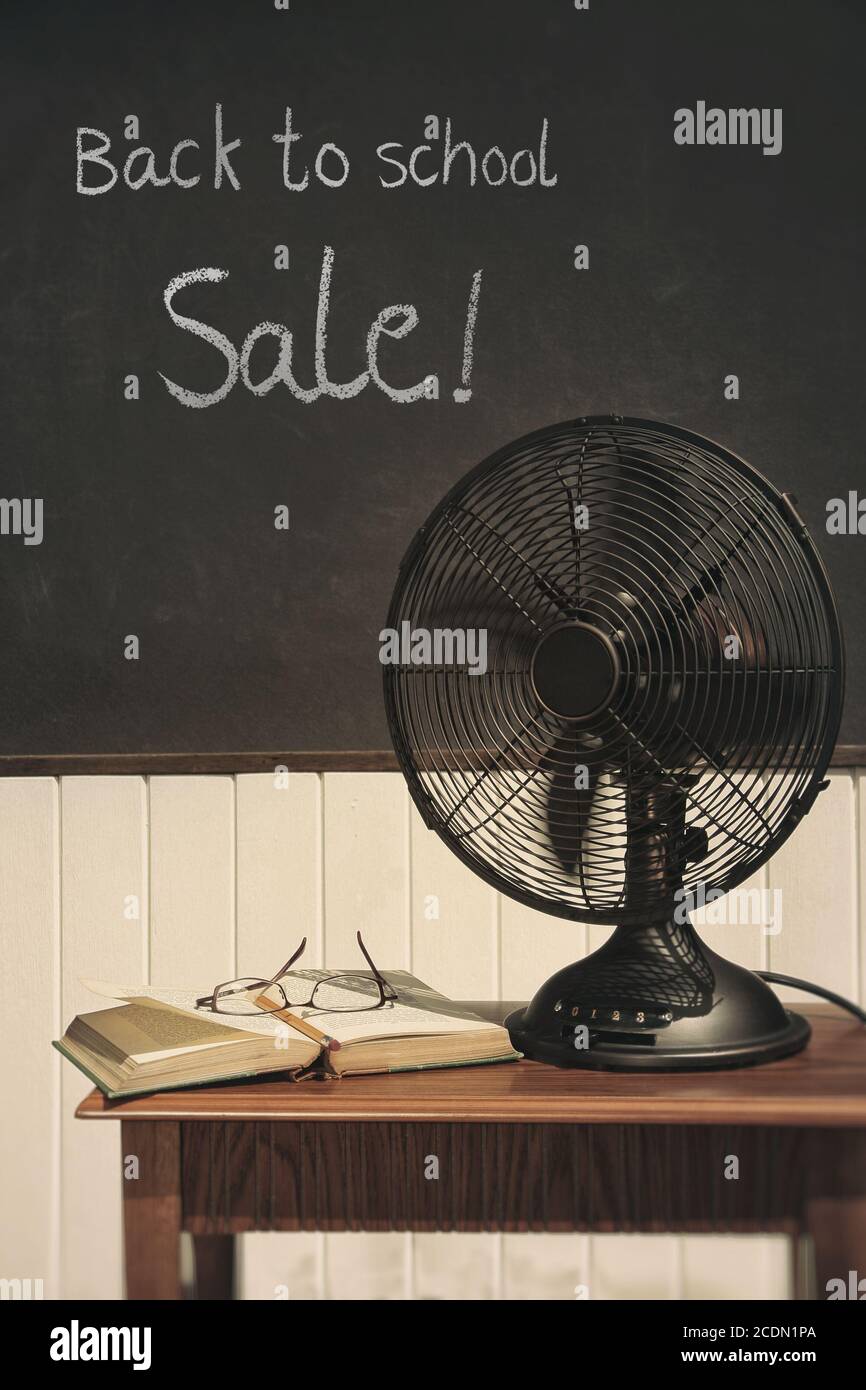 Vintage electric fan with book on table Stock Photo