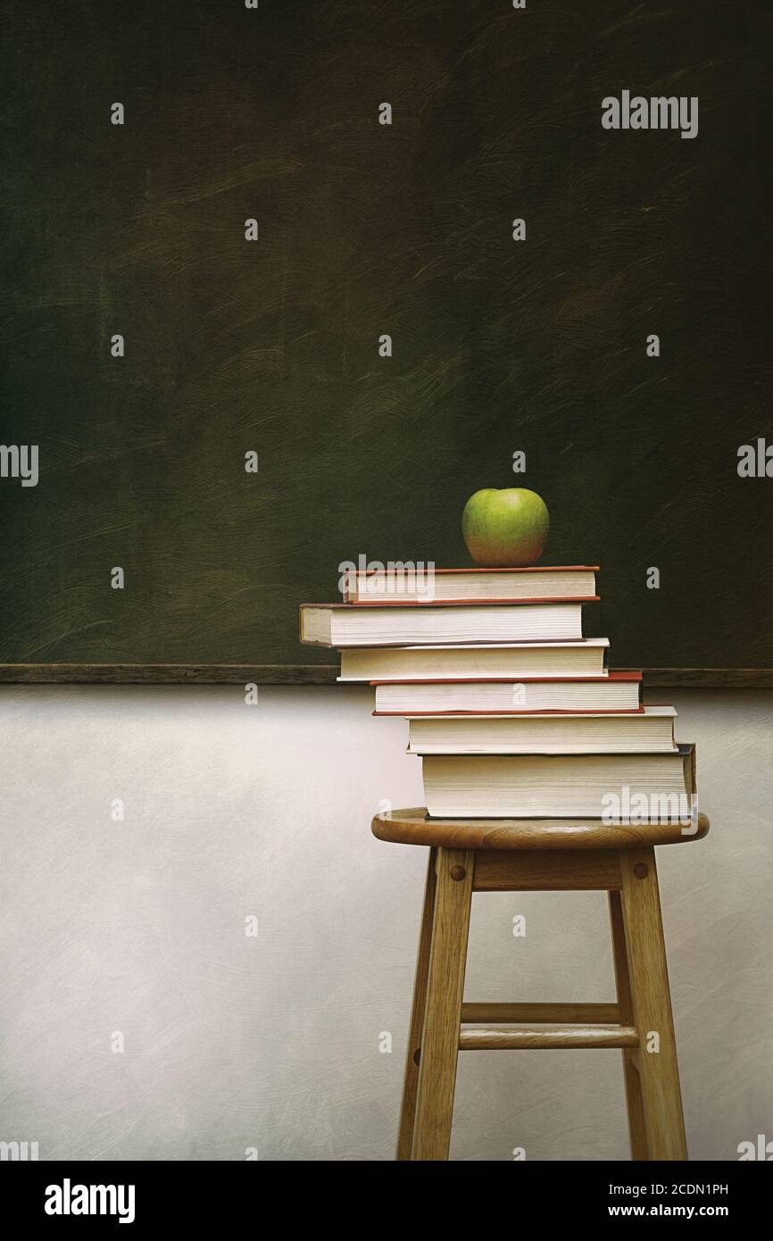 Pile of books and apple on stool with vintage feel Stock Photo