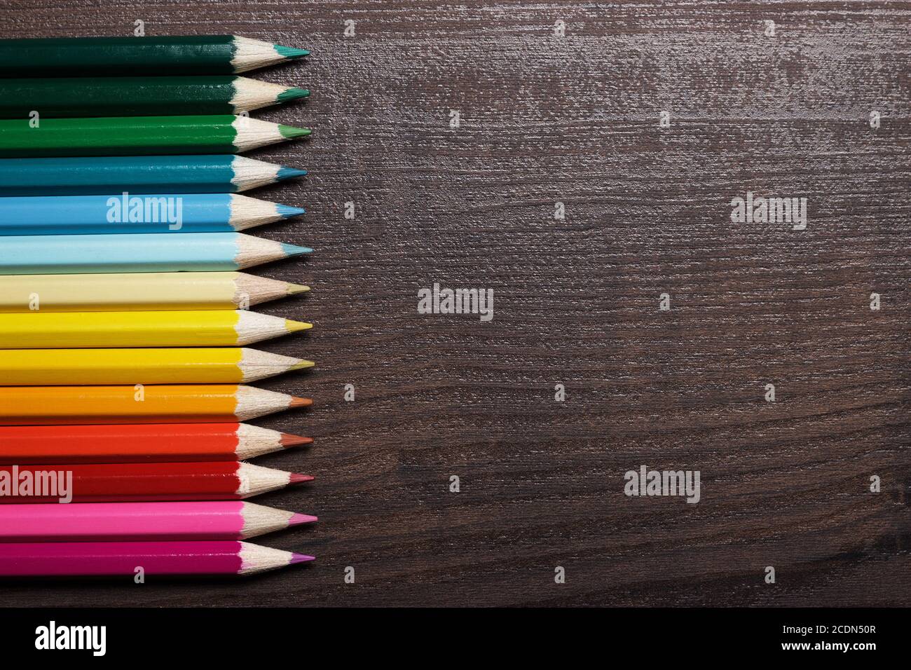 multicolored pencils on the brown wooden table background Stock Photo