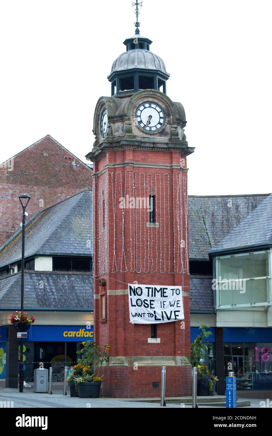 The Clock Tower, Bangor, Gwynedd 29 August 2020. Climate activists from Extinction Rebellion hang banners on the town clock in the early hours of the morning as part of a series of actions taking place across the UK over the next four days. Credit: Denise Laura Baker/Alamy Live News Stock Photo