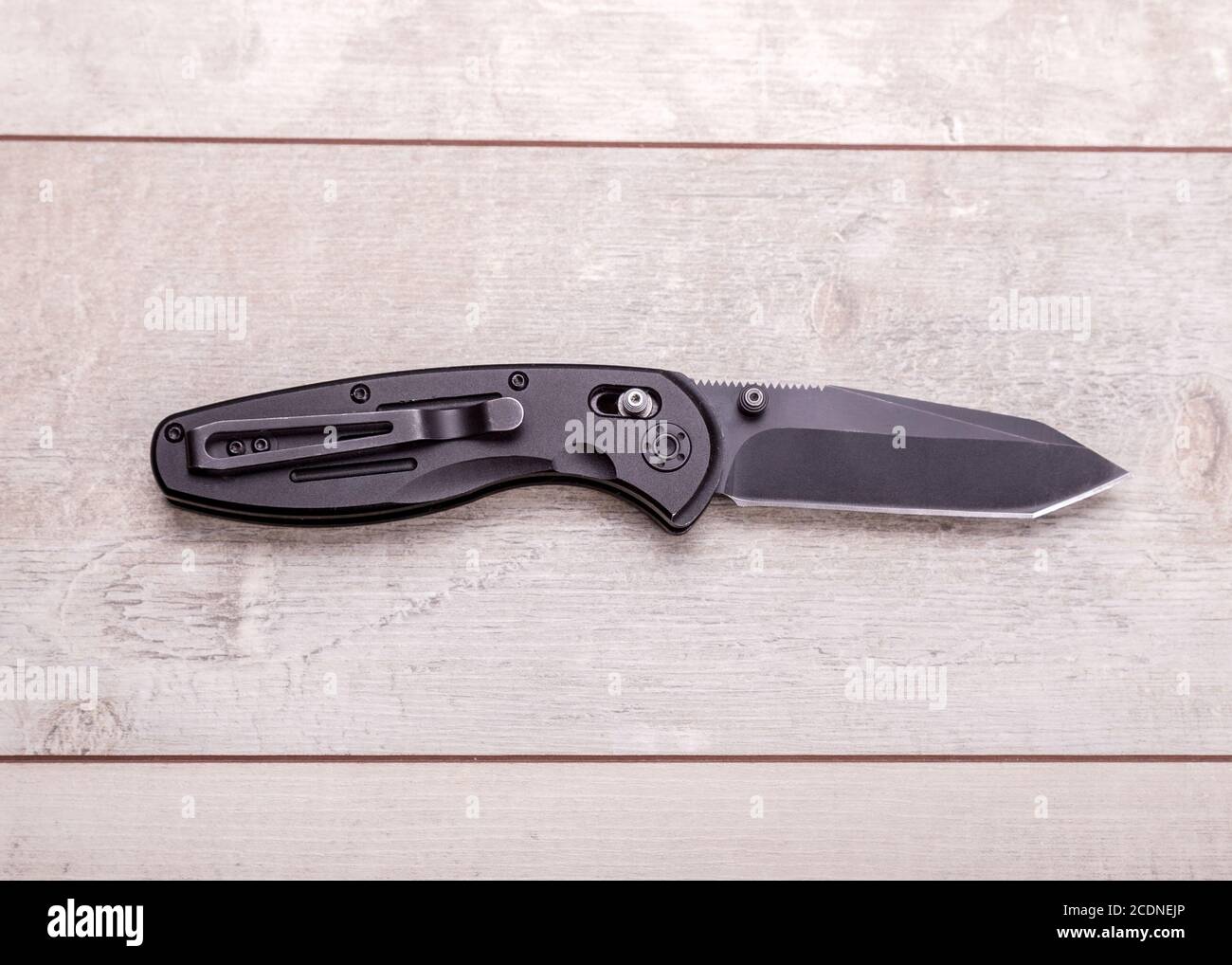Folding knife on a wooden background Stock Photo