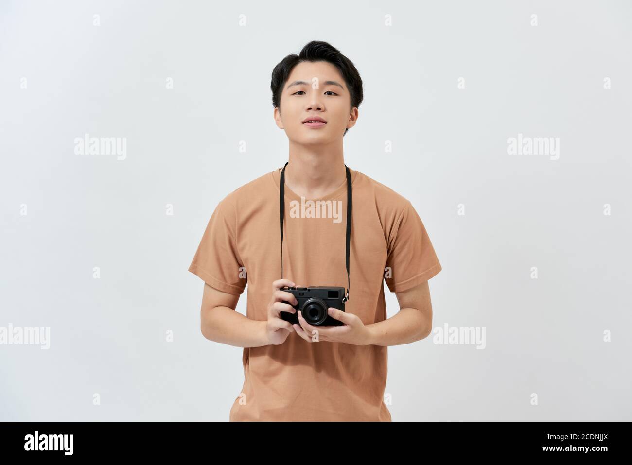Amazing guy with photo digicam in hands wear casual t-shirt isolated on white background. Stock Photo