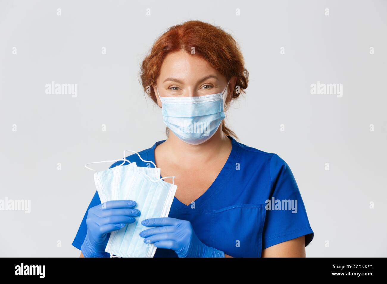 Medical workers, covid-19 pandemic, coronavirus concept. Close-up of smiling caring female nurse, doctor in rubber gloves ask to use face masks and Stock Photo