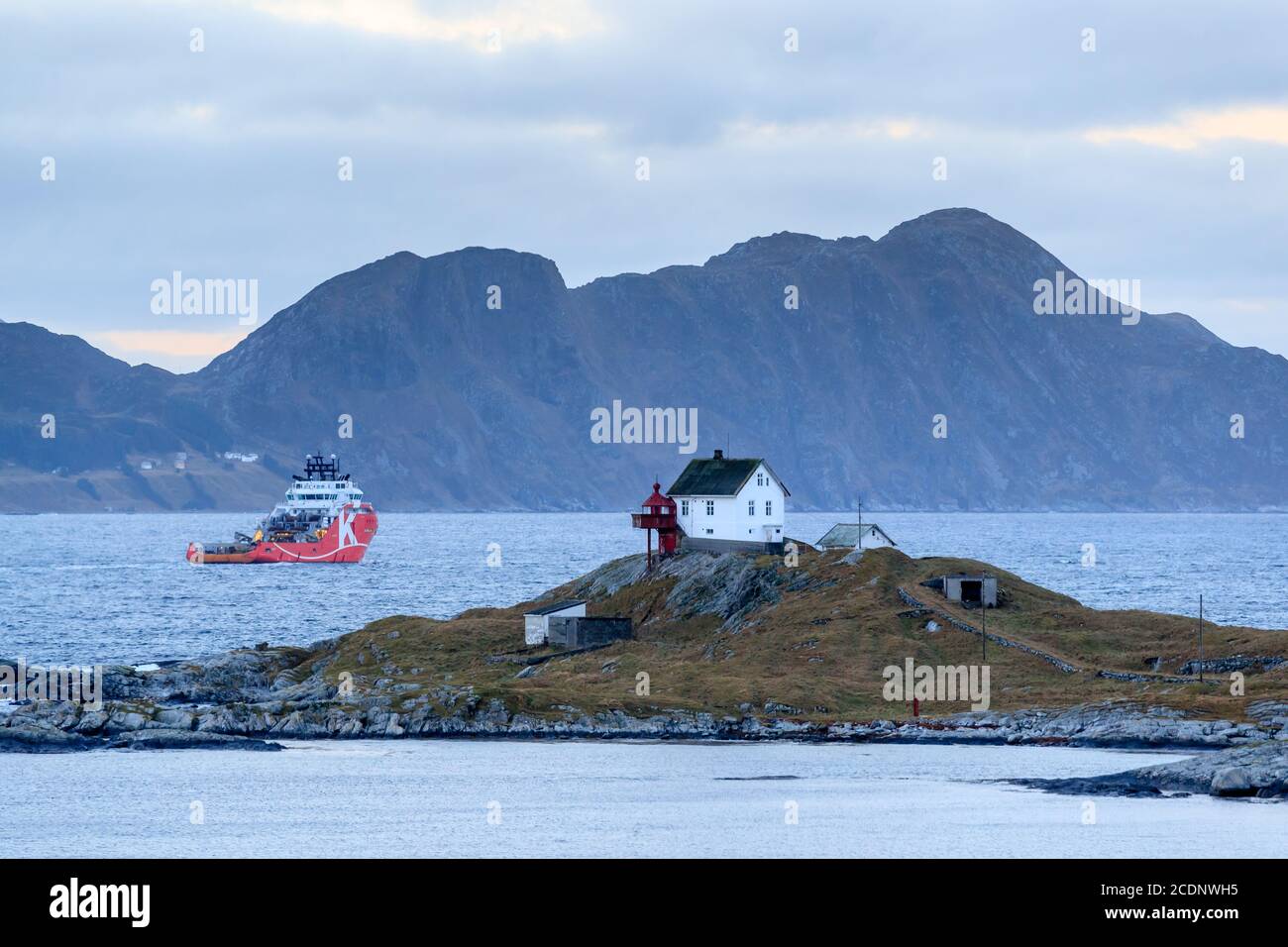 HAUGSHOLMEN LIGHTHOUSE, NORWAY - 2016 DECEMBER 05. Offshore vessel AHTS passing the Haugsholmen Lighthouse. Stock Photo