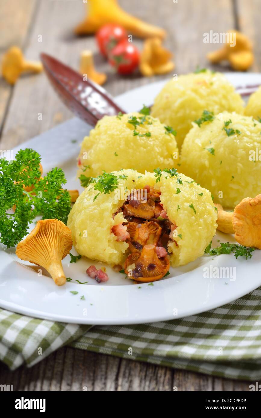Hearty autumn potato dumplings stuffed with butter fried chanterelles and bacon cubes Stock Photo
