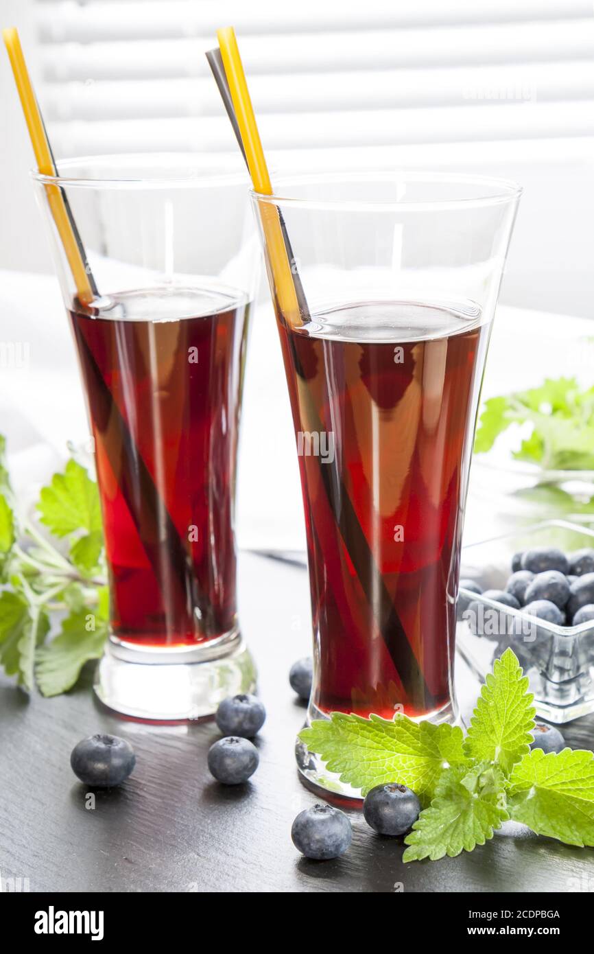 Glasses with fresh Black Currant juice. Bog blueberry and lemon balm Stock Photo