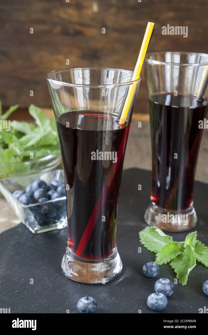 Glasses with fresh Black Currant juice. Bog blueberry and lemon balm Stock Photo
