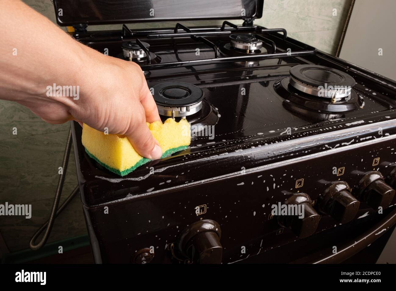 wash the gas stove with a washcloth,cleaning the kitchen Stock Photo
