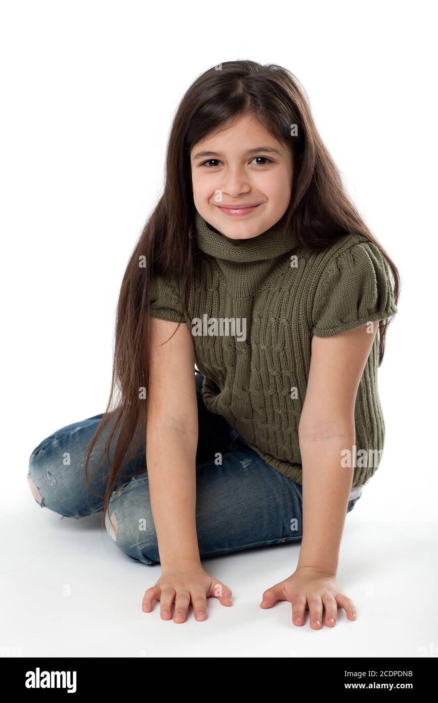 Happy looking young girl sitting on the ground Stock Photo