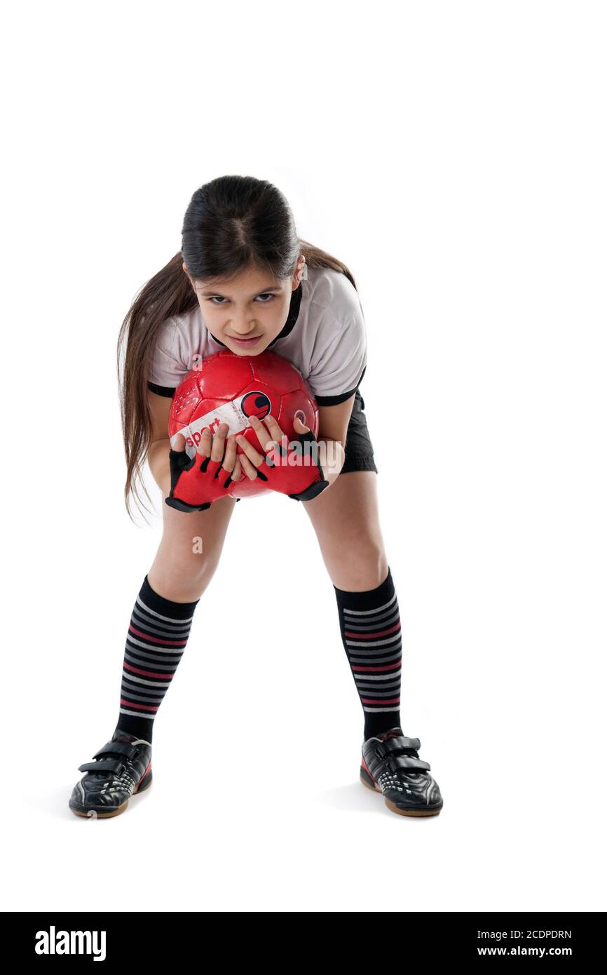 Grimly-looking young girl in soccer clothes holding a ball Stock Photo