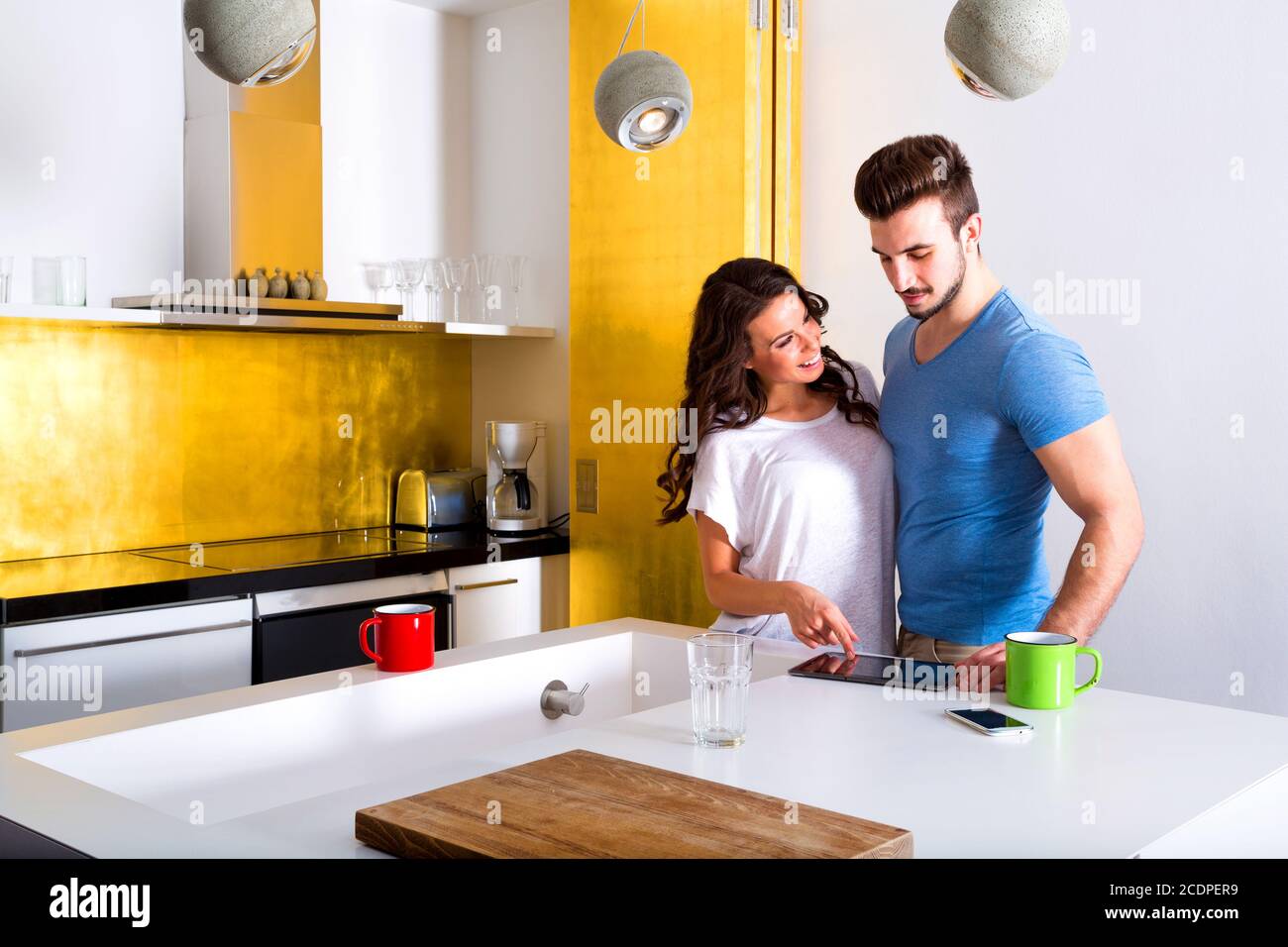 Young couple using a Tablet PC in the kitchen at home Stock Photo