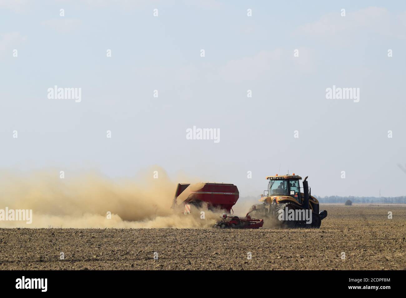Tractor rides on the field and makes the fertilizer into the soil. Fertilizers after plowing the field. Stock Photo