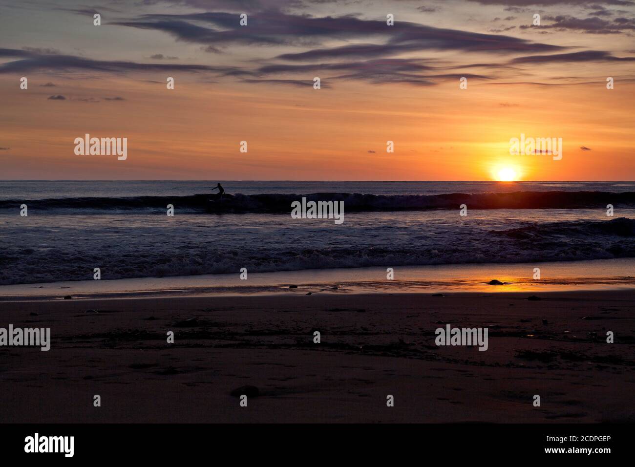 Surfers on the beach of Santa Teresa at sunset / Costa Rica Stock Photo