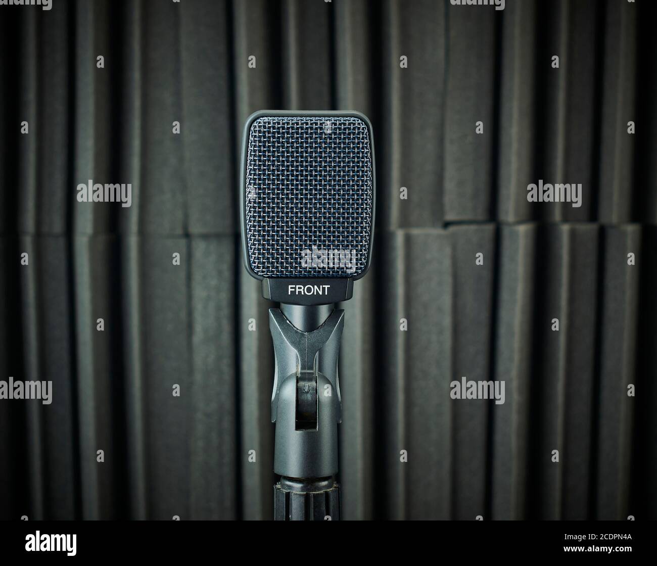 Front view of dynamic microphone for vocals and choirs mounted on stand, gray, on acoustic foam background Stock Photo