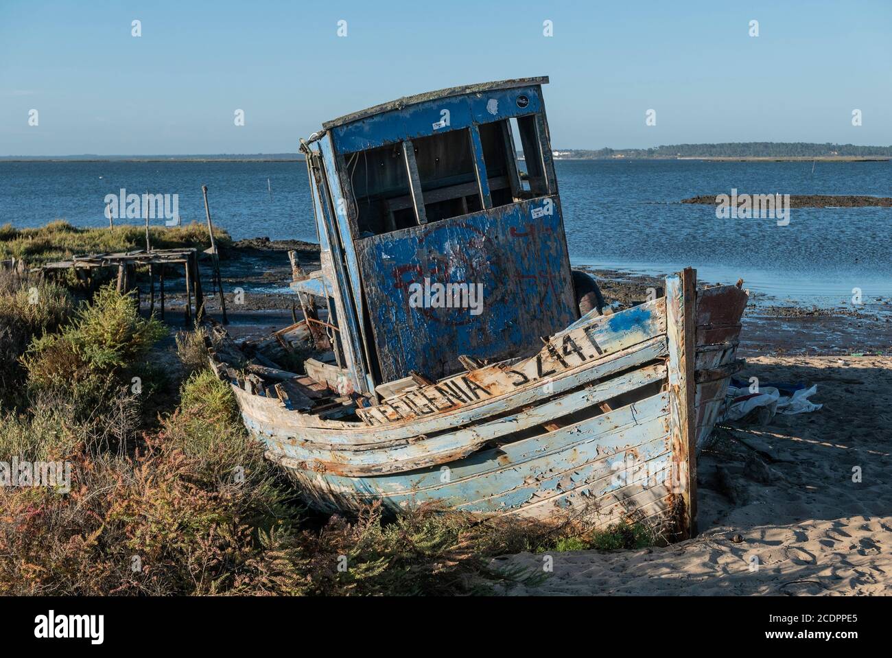 Weathered fishing boat grounded at low tide Stock Photo