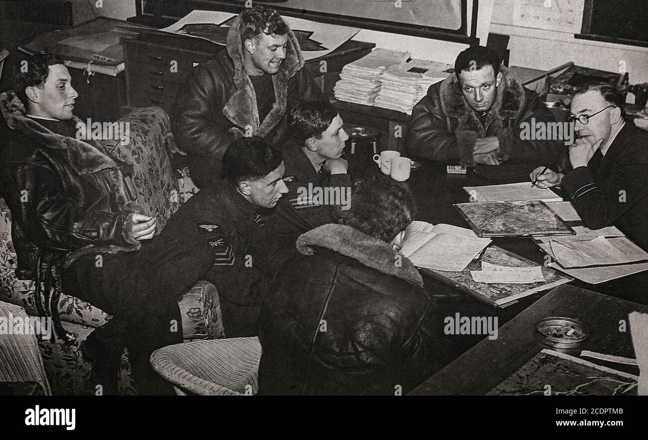 Aircrew undergoing debriefing by a Squadron Intelligence Officer following their safe return from a bombing mission over Germany Stock Photo
