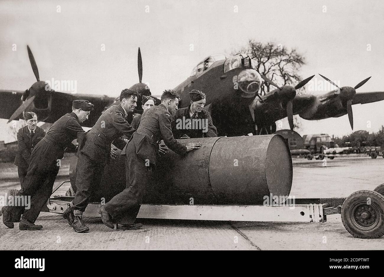 A 4,000 pound blast bomb being fitted to a Lancaster. Also called the blockbuster bomb, a term originally coined by the press and referred to a bomb which had enough explosive power to destroy an entire street or large building through the effects of blast in conjunction with incendiary bombs. Stock Photo