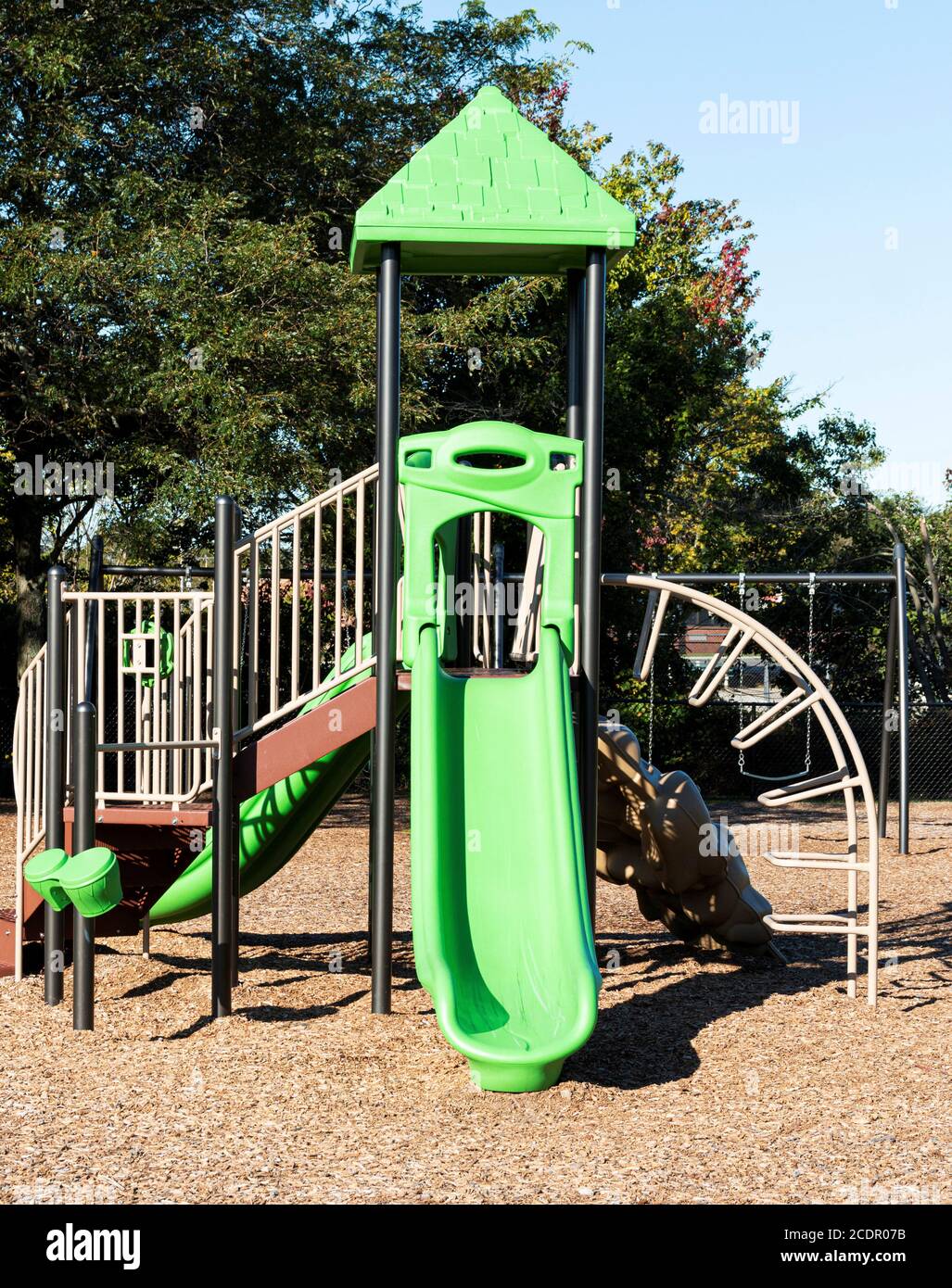 A public playground for kids with green slides and things to climb on. Stock Photo